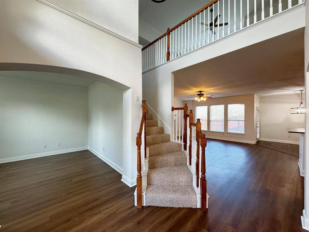 4531 Oak Shores Drive, Plano, TX 75024 Two-story foyer with carpeted staircase, wood-finish flooring, and an arched entry