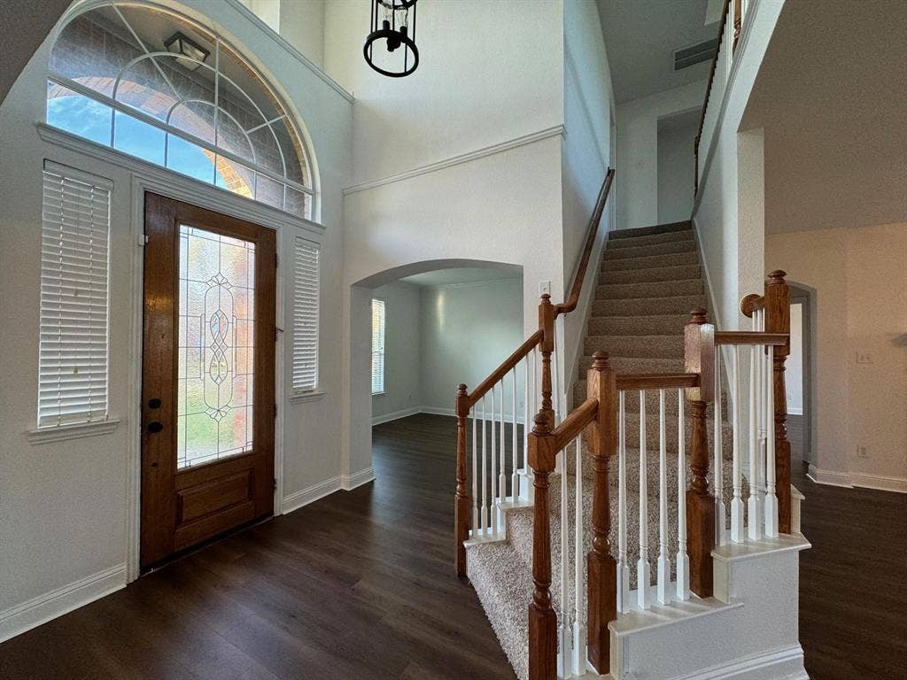4531 Oak Shores Drive, Plano, TX 75024 Two-story entryway featuring wood-finish flooring, a decorative glass front door, and a staircase with wood newel posts and white balusters