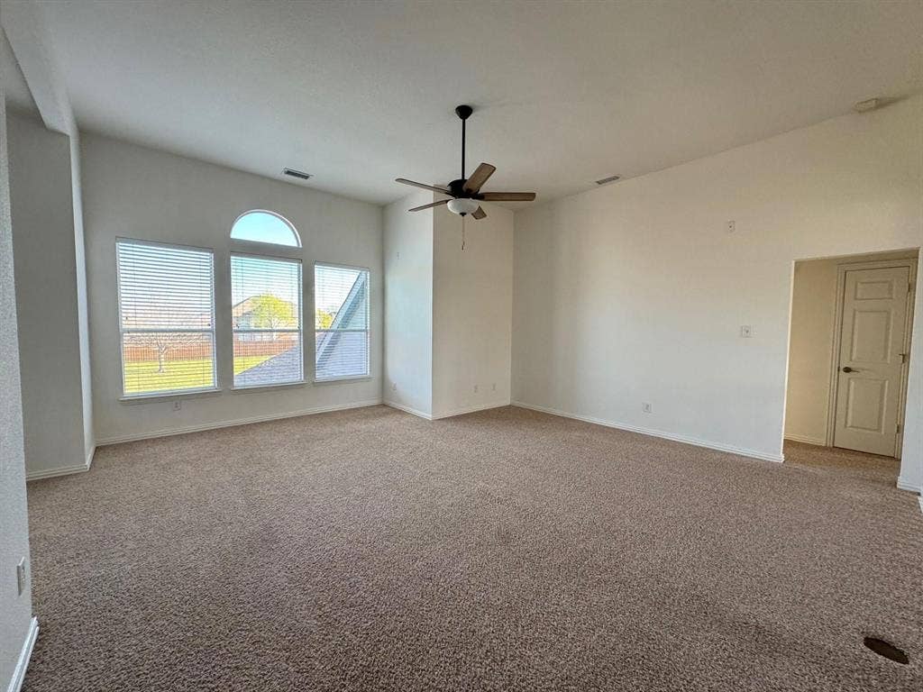 4531 Oak Shores Drive, Plano, TX 75024 Expansive room featuring vaulted ceilings, a ceiling fan, and multiple windows with an arched transom