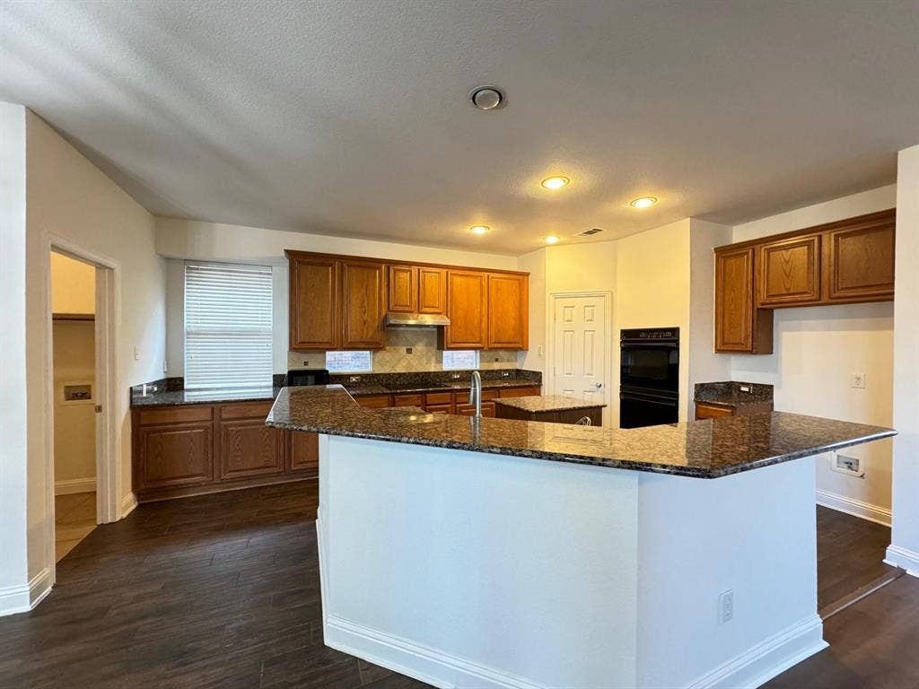 4531 Oak Shores Drive, Plano, TX 75024 Kitchen featuring wood-finish flooring, recessed lighting, wood cabinetry, stone countertops, and built-in double ovens