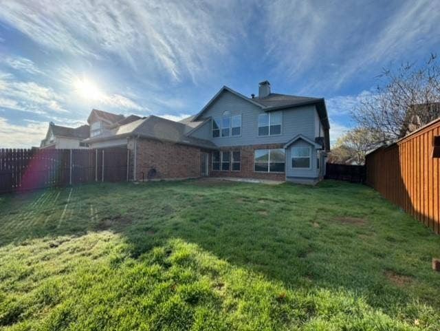 4531 Oak Shores Drive, Plano, TX 75024 Expansive backyard with a manicured lawn, brick and siding exterior, multiple windows, and a privacy fence