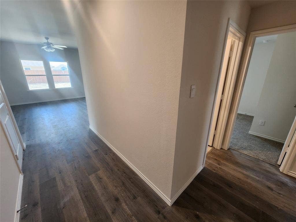 1302 Breezy Oak Drive, Nevada, TX 75173 Wood-finish flooring throughout the main areas, with light gray carpeting in additional rooms