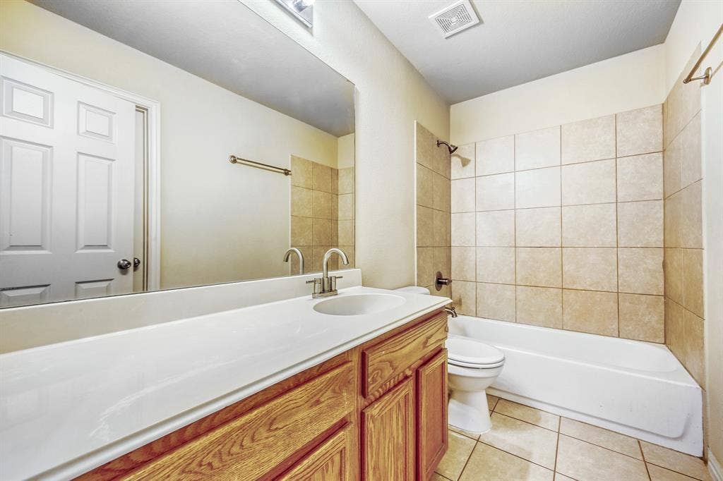 1012 Surrey Drive, DeSoto, TX 75115 Wood-finish vanity with an integrated sink and brushed nickel faucet