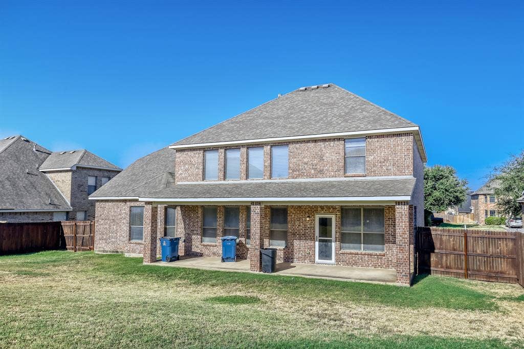 1012 Surrey Drive, DeSoto, TX 75115 Brick exterior with a shingle roof and a covered patio