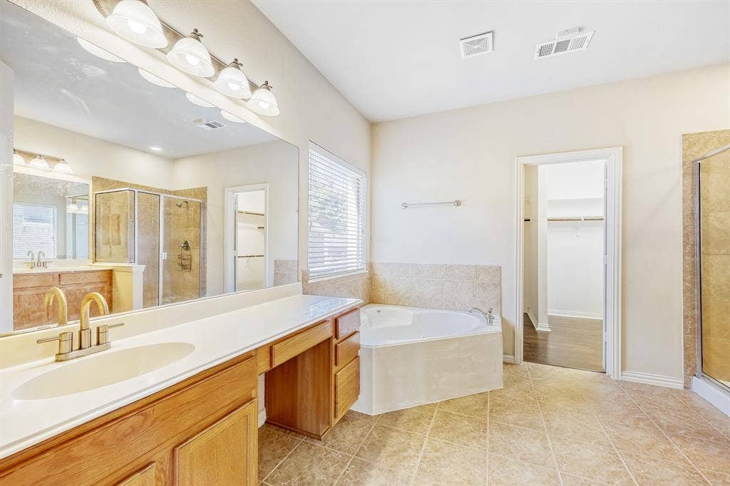 1012 Surrey Drive, DeSoto, TX 75115 Dual vanity with brass-finish fixtures and an integrated makeup counter