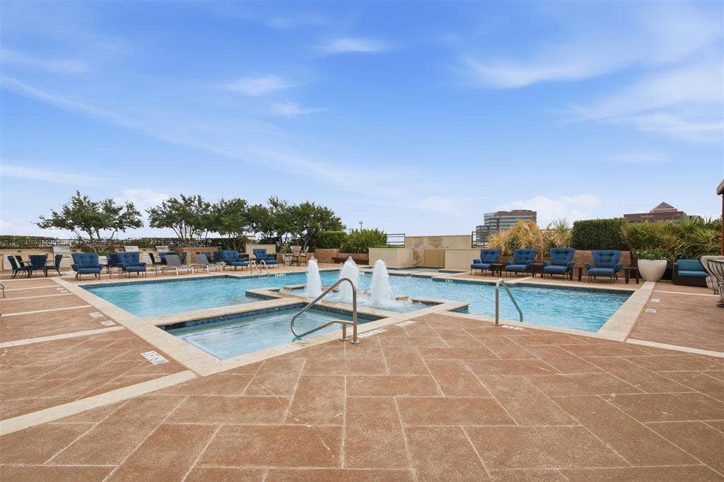 330 Las Colinas Boulevard E, #1216, Irving, TX 75039 Expansive outdoor pool area featuring a multi-level swimming pool with water features, a hot tub, and surrounding lounge seating