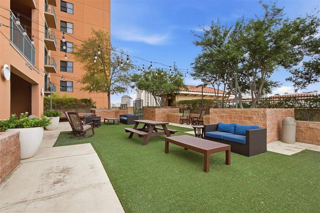 330 Las Colinas Boulevard E, #1216, Irving, TX 75039 Expansive outdoor terrace featuring artificial turf, string lighting, and stone planter walls