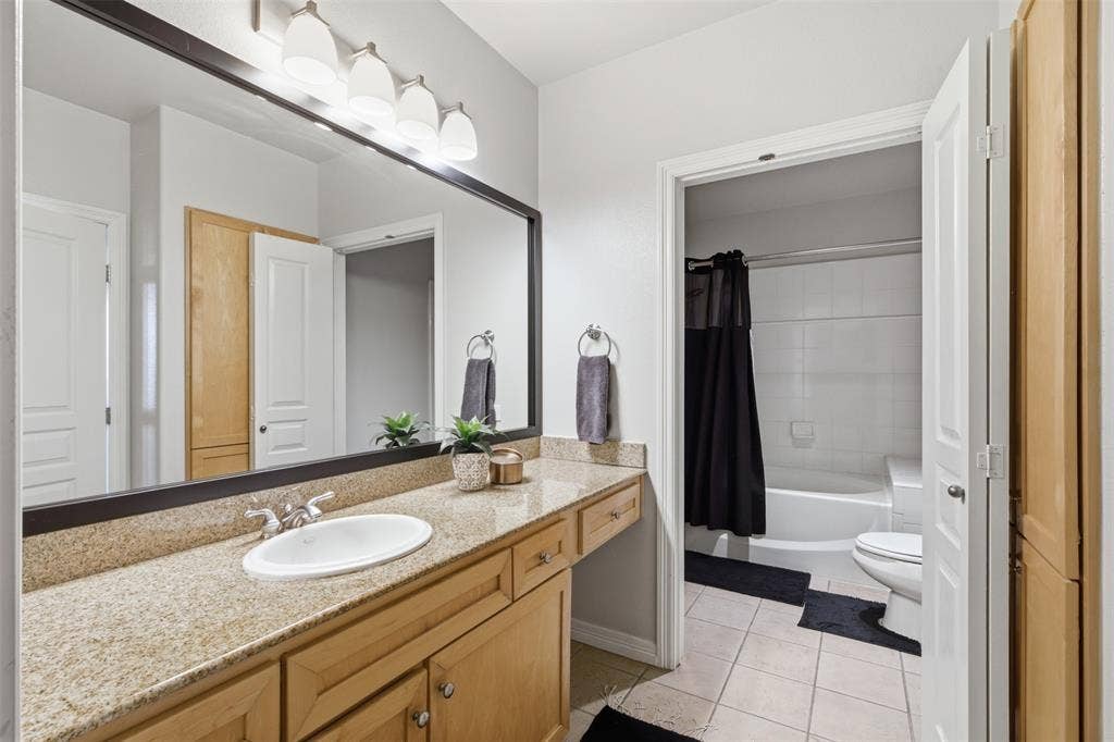 330 Las Colinas Boulevard E, #1216, Irving, TX 75039 Spacious bathroom vanity featuring a granite countertop, undermount sink, and wood-finish cabinetry