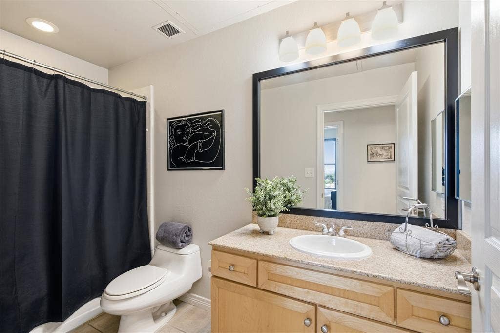 330 Las Colinas Boulevard E, #1216, Irving, TX 75039 Single vanity with light wood-finish cabinetry, a stone-finish countertop, and an undermount sink