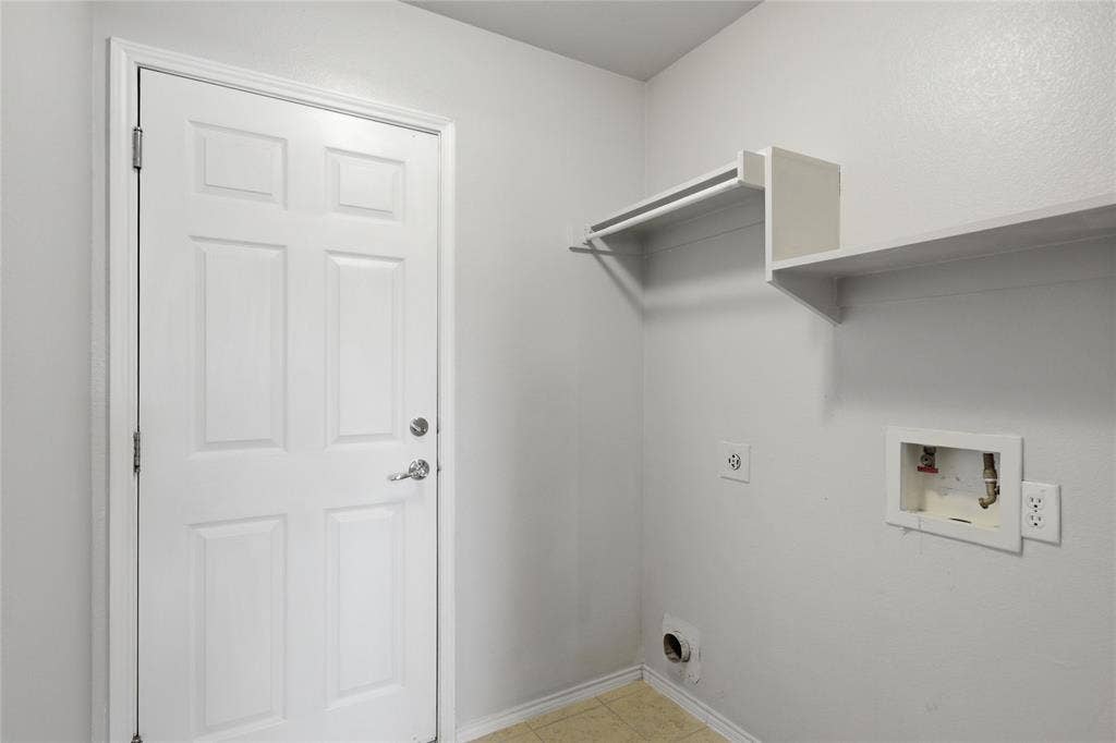 217 Ame Lane, Royse City, TX 75189 Utility space featuring a paneled door, integrated shelving, and a garment rod