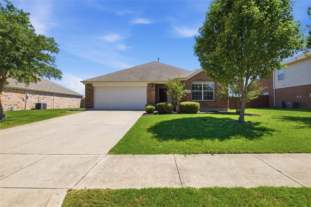 217 Ame Lane, Royse City, TX 75189 Brick facade, attached garage, concrete driveway, mature trees, manicured lawn