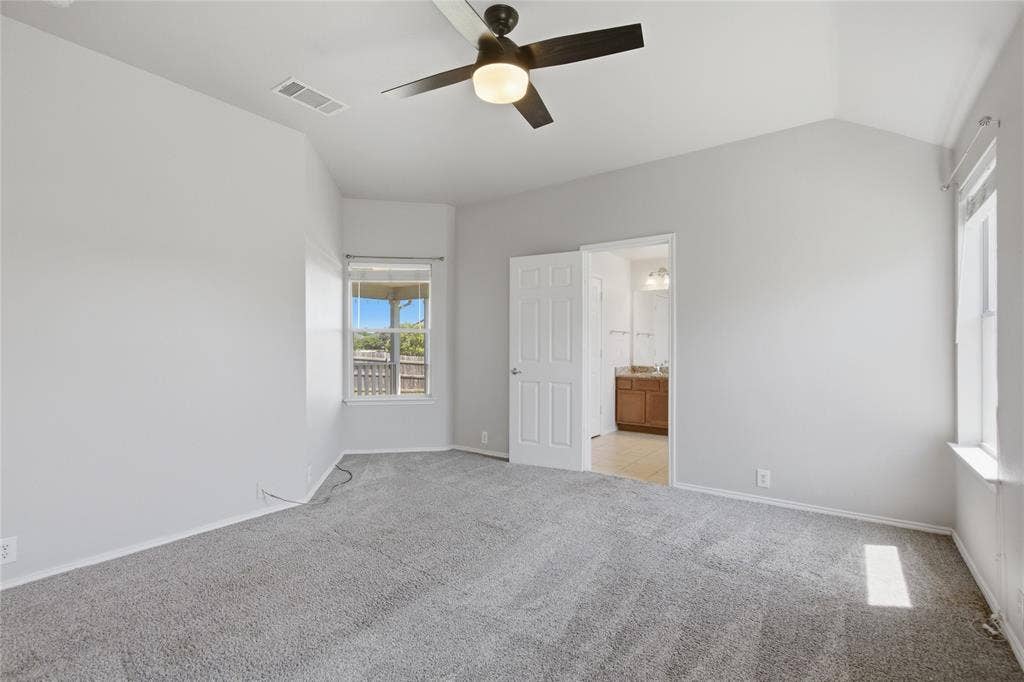 217 Ame Lane, Royse City, TX 75189 Vaulted ceiling with an attached ceiling fan, two windows providing natural light, and plush gray carpeting