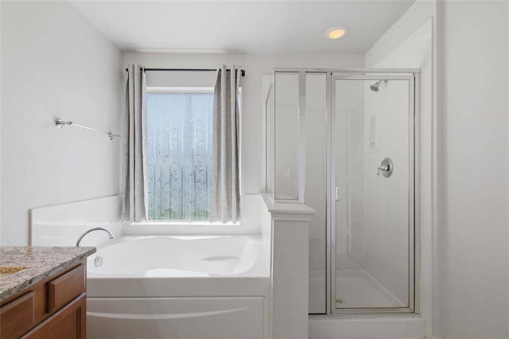217 Ame Lane, Royse City, TX 75189 Built-in soaking tub, separate glass-enclosed shower, single vanity with wood cabinetry, and recessed lighting