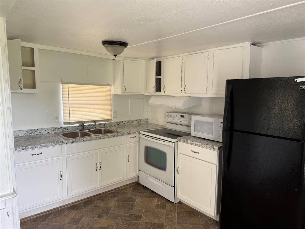 Kitchen with refrigerator, oven, stove, and microwave