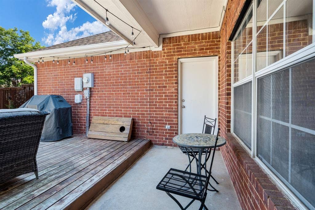 11414 Promenade Road, Frisco, TX 75035 Covered outdoor patio featuring brick exterior, wood-finish decking, and string lighting