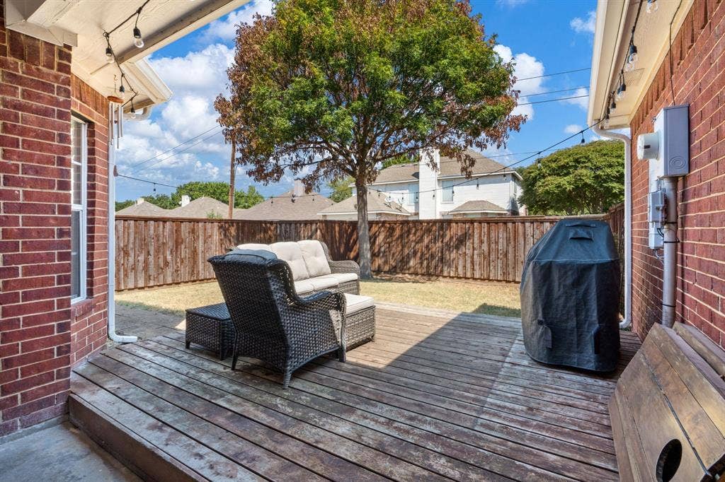 11414 Promenade Road, Frisco, TX 75035 Wood deck patio with string lighting and brick exterior