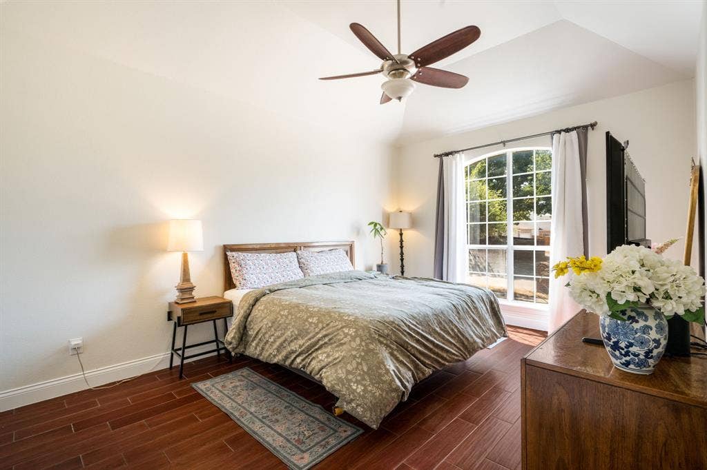 11414 Promenade Road, Frisco, TX 75035 Vaulted ceiling with a ceiling fan, arched window, wood-finish flooring, and light-toned walls