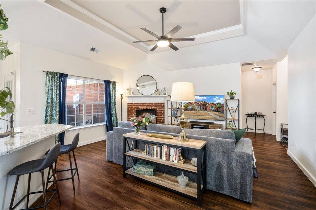 11414 Promenade Road, Frisco, TX 75035 Open-concept living area with wood-finish flooring, a tray ceiling, and a ceiling fan