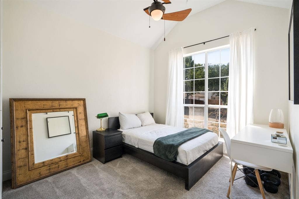11414 Promenade Road, Frisco, TX 75035 Vaulted ceiling with an attached ceiling fan, large multi-pane window with white curtains, and neutral wall paint