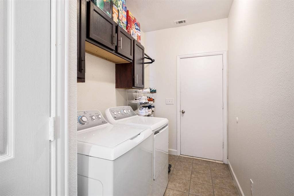 11414 Promenade Road, Frisco, TX 75035 Laundry area featuring tile flooring, dark wood-finish cabinetry, and a built-in hanging rod