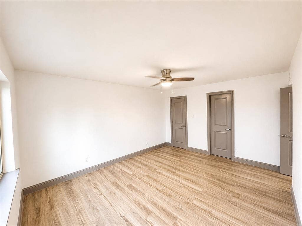 4316 Woodbluff Drive, Mesquite, TX 75150 Spacious room featuring wood-finish flooring, white walls, and a ceiling fan with integrated lighting