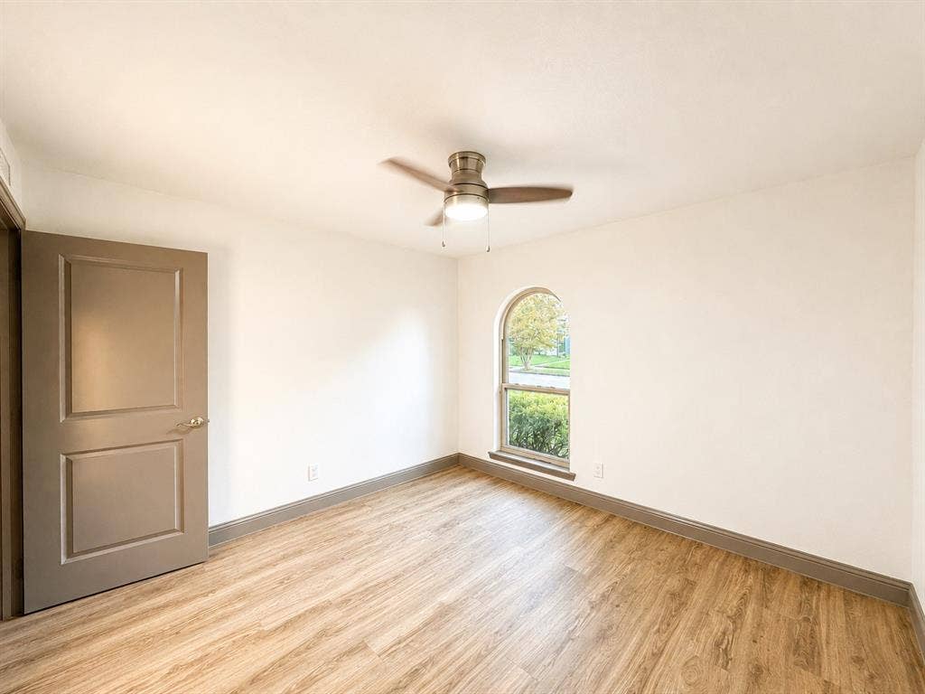 4316 Woodbluff Drive, Mesquite, TX 75150 Wood-finish flooring, arched window, ceiling fan, and painted interior door