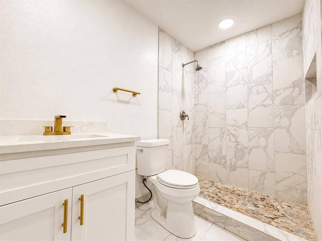 4316 Woodbluff Drive, Mesquite, TX 75150 White vanity with quartz countertop, brass-finish faucet, and integrated sink