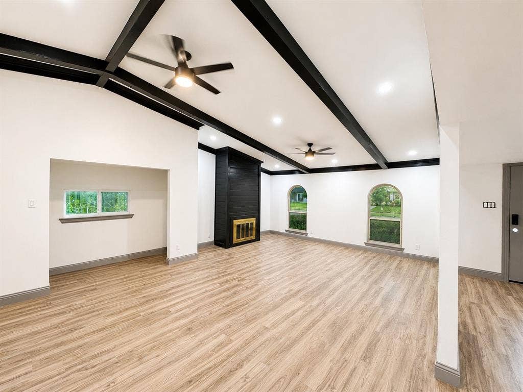 4316 Woodbluff Drive, Mesquite, TX 75150 Recessed lighting throughout, wood-finish flooring, two modern ceiling fans, black accent fireplace, and two arched windows
