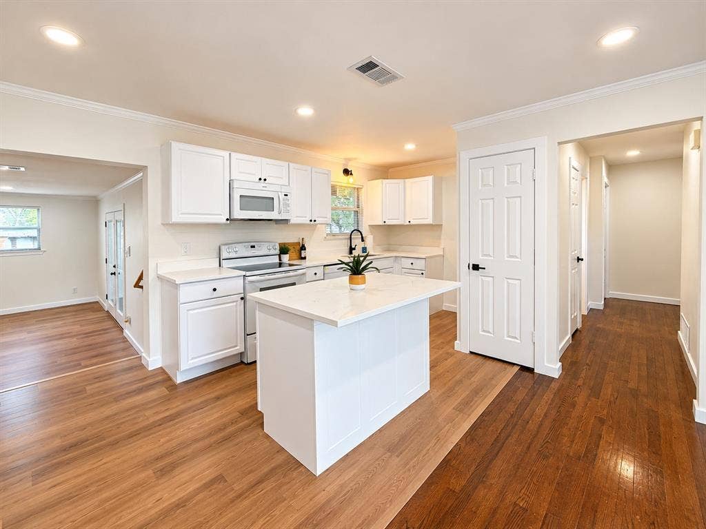 1737 Alta Vista Street, Mesquite, TX 75149 Kitchen featuring white shaker-style cabinetry, central island with stone-surface countertop, wood-finish flooring, recessed lighting, and matte black hardware