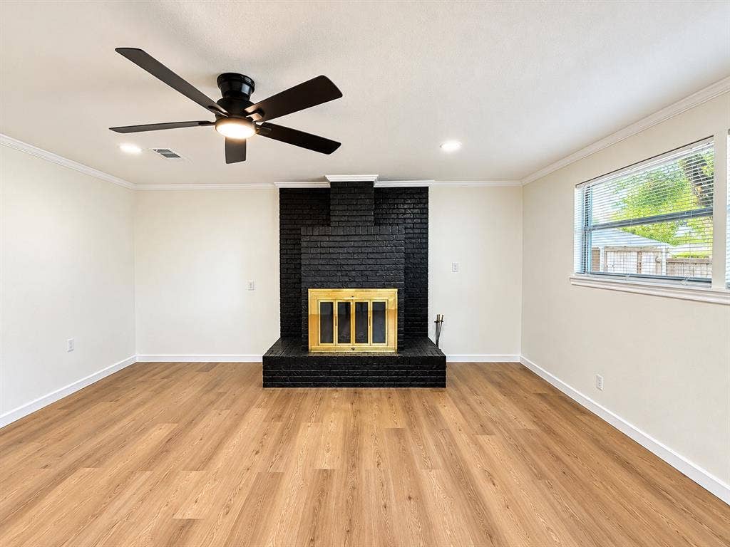 1737 Alta Vista Street, Mesquite, TX 75149 Black painted brick fireplace with brass-finish screen, wood-finish flooring, recessed lighting, and matte black ceiling fan