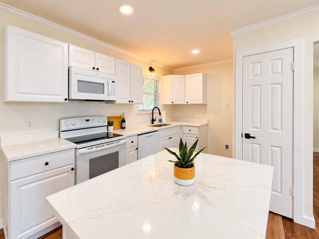 1737 Alta Vista Street, Mesquite, TX 75149 Kitchen featuring white shaker-style cabinetry, quartz countertops, a center island, subway tile backsplash, and a matte black faucet