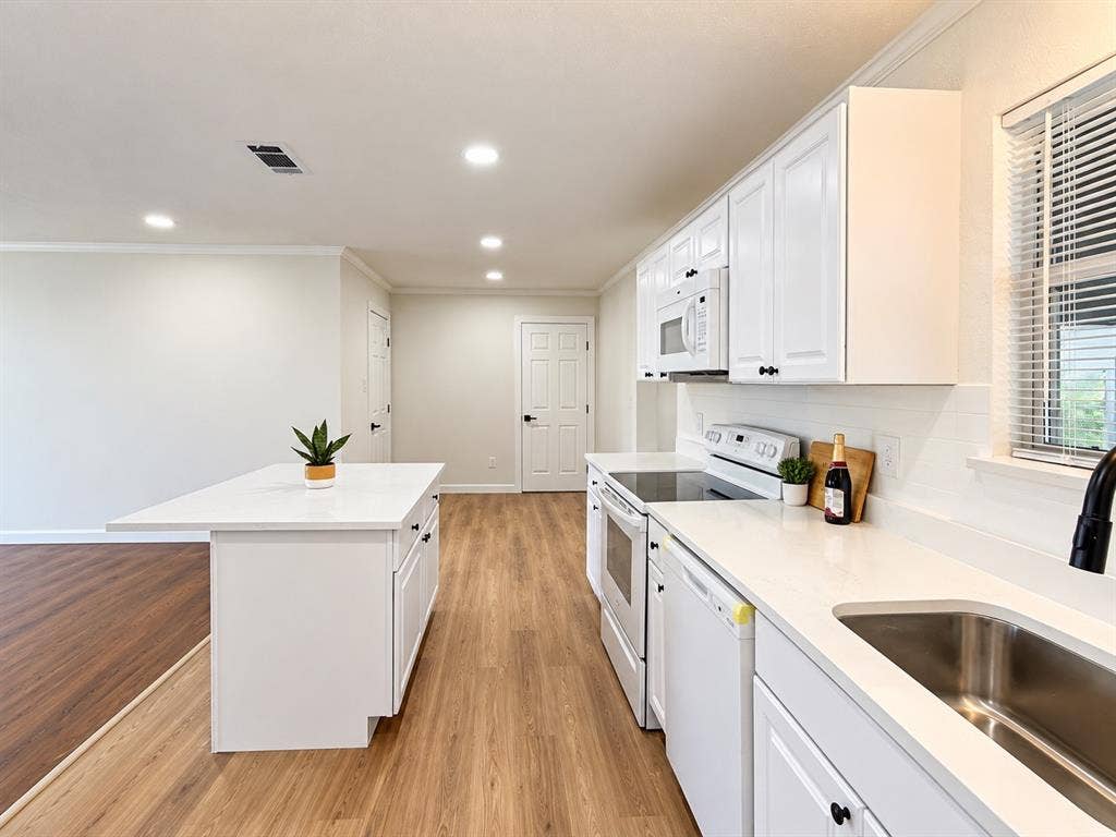 1737 Alta Vista Street, Mesquite, TX 75149 Kitchen featuring white shaker-style cabinetry, quartz countertops, a central island, recessed lighting, and wood-finish flooring