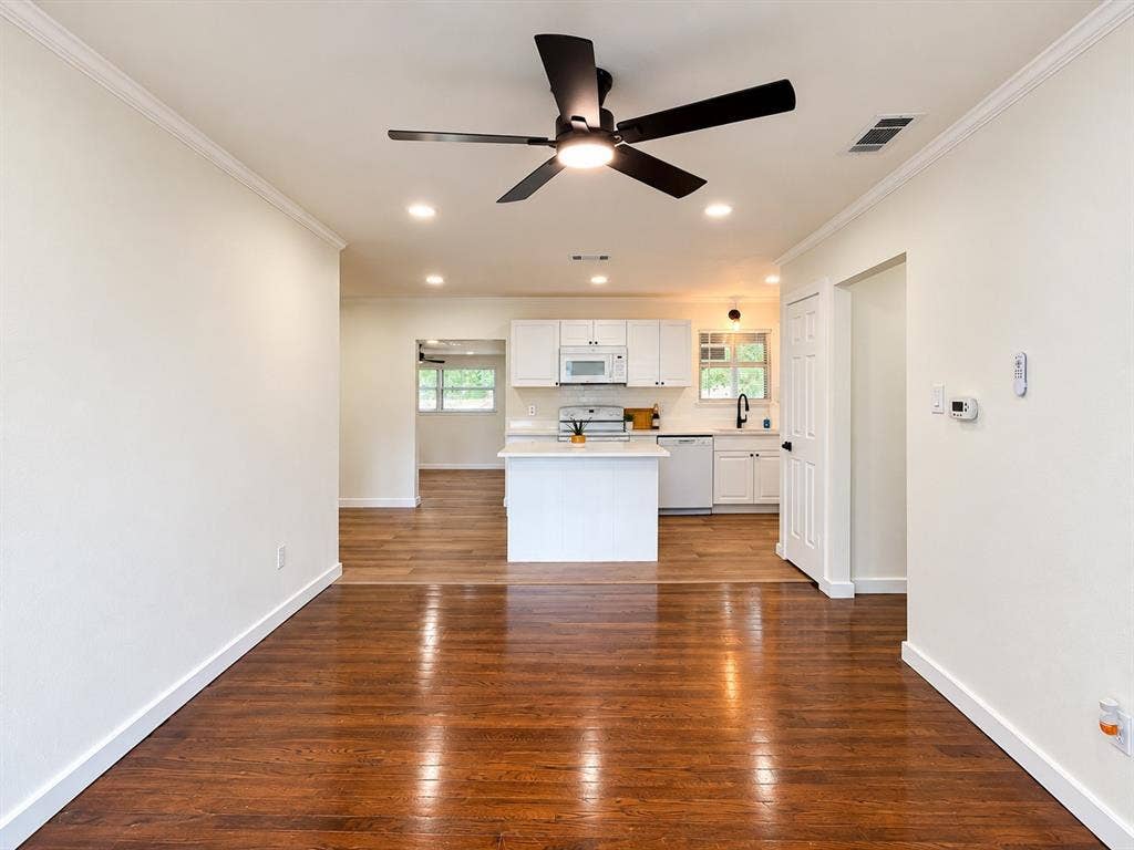 1737 Alta Vista Street, Mesquite, TX 75149 Interior space featuring wood-finish flooring, recessed lighting, matte black ceiling fan, and kitchen equipped with white cabinetry, a center island, and white appliances