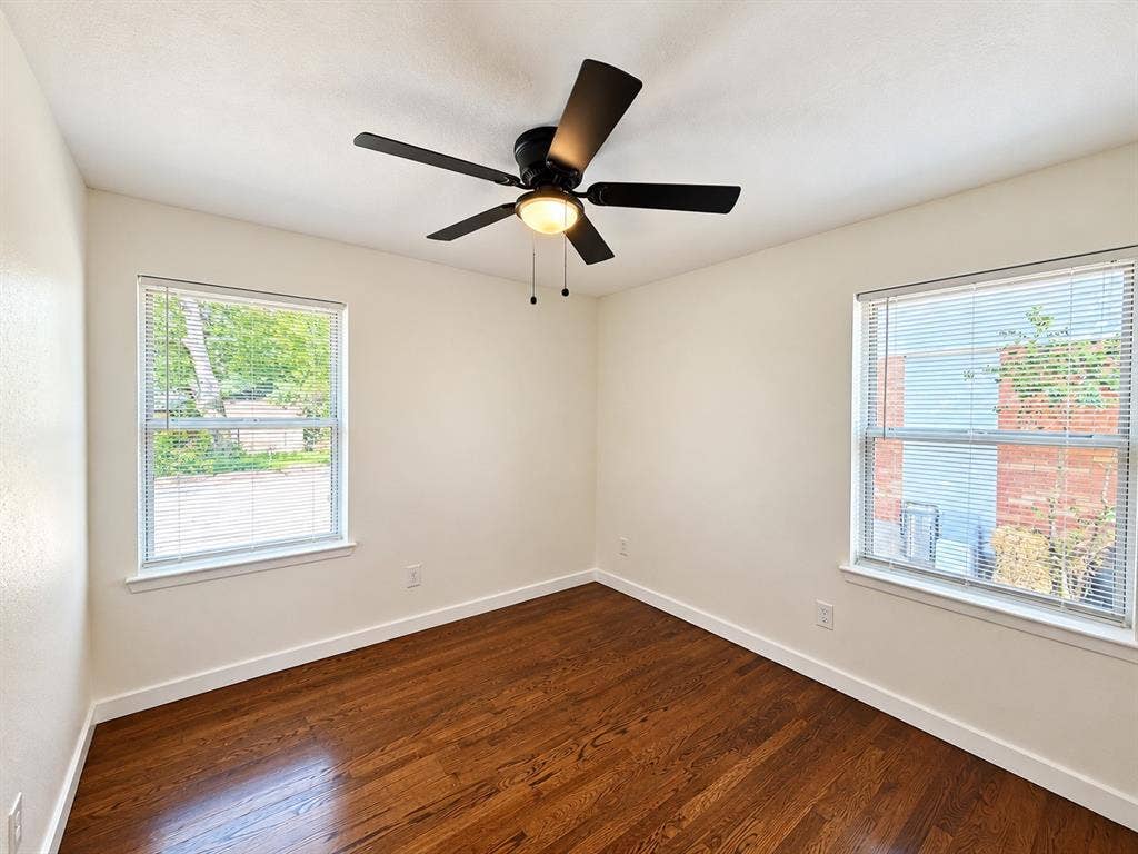 1737 Alta Vista Street, Mesquite, TX 75149 Room featuring wood-finish flooring, dual windows with blinds, and a matte black ceiling fan with an integrated light fixture