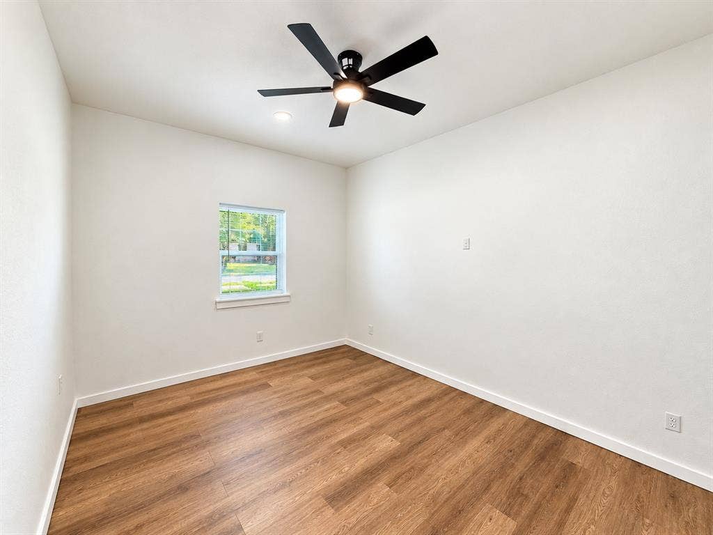 1737 Alta Vista Street, Mesquite, TX 75149 Wood-finish flooring, matte black ceiling fan with integrated lighting, and single-pane window