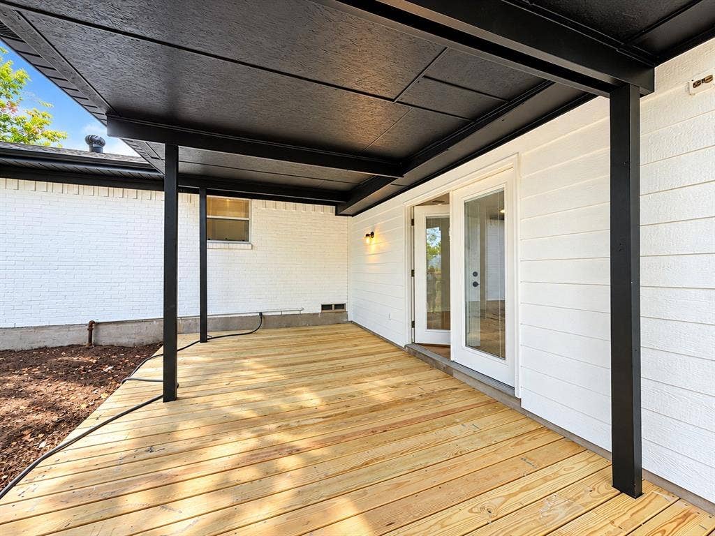 1737 Alta Vista Street, Mesquite, TX 75149 Covered patio featuring wood decking, white horizontal siding, white painted brick masonry, and black support columns