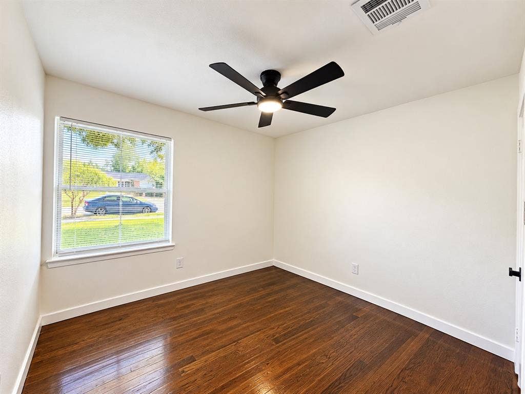 1737 Alta Vista Street, Mesquite, TX 75149 Neutral-toned interior room featuring wood-finish flooring, a multi-blade ceiling fan with integrated lighting, and a window with horizontal blinds