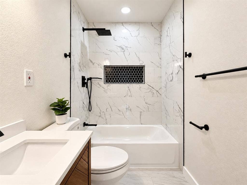 1737 Alta Vista Street, Mesquite, TX 75149 Bathroom featuring a tub-shower combination with floor-to-ceiling large-format tile surround, recessed honeycomb-tile shower niche, matte black rainfall showerhead with handheld sprayer, and vanity with a white countertop