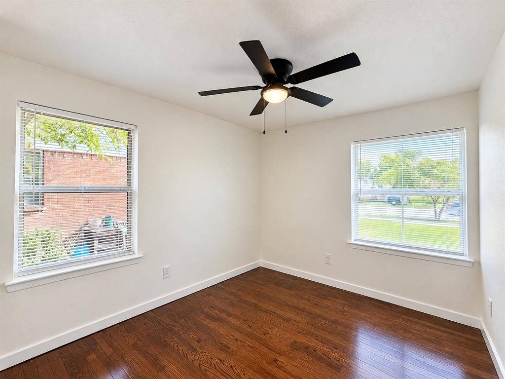1737 Alta Vista Street, Mesquite, TX 75149 Interior room featuring wood-finish flooring, two dual-pane windows with horizontal blinds, and a central ceiling fan with an integrated light fixture