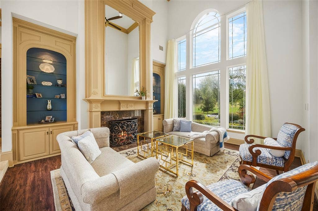 508 Moraine Way, Heath, TX 75032 Elegant formal living room with floor-to-ceiling windows and a beautiful fireplace.