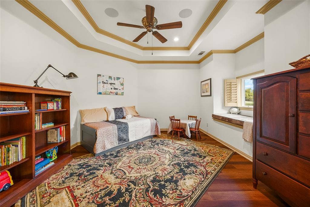 508 Moraine Way, Heath, TX 75032 Beautifully appointed bedroom with tray ceiling and warm wood finishes.
