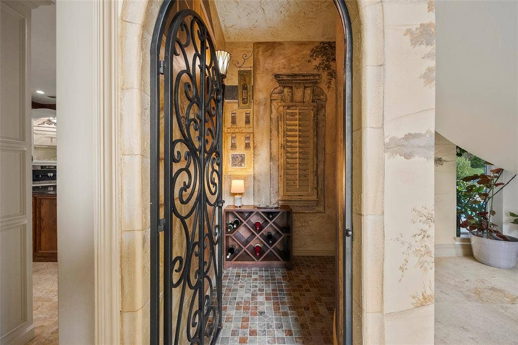 508 Moraine Way, Heath, TX 75032 Walk-in wine closet with custom storage and decorative iron door.