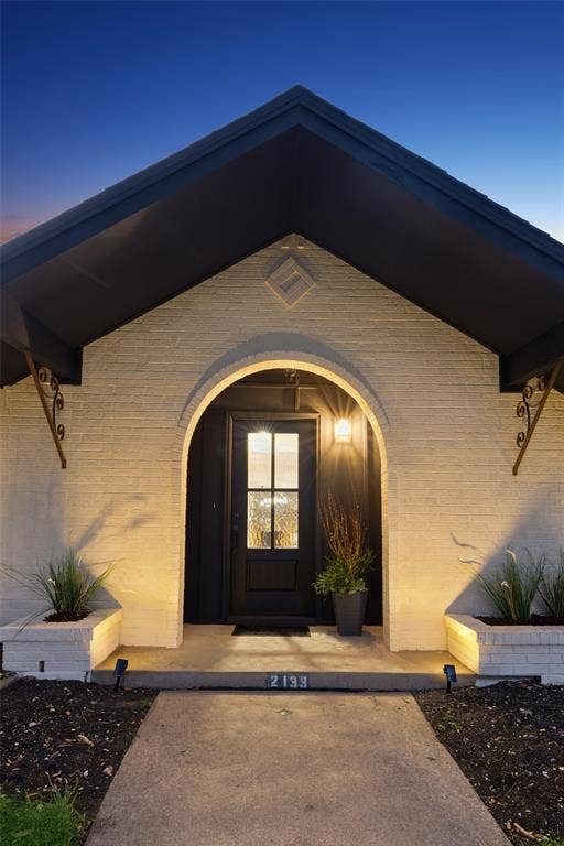2133 Oak Valley Lane, Dallas, TX 75232 Arched entryway with a dark-paneled door and transom window