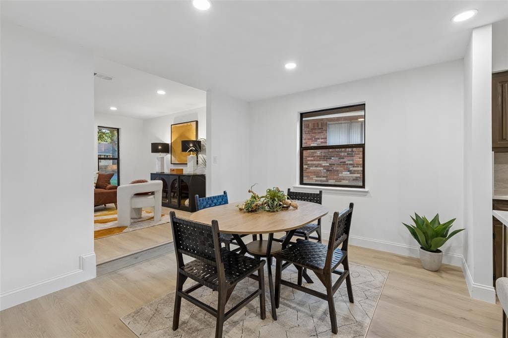 2133 Oak Valley Lane, Dallas, TX 75232 Open-concept dining area featuring recessed lighting, wood-finish flooring, and a large window with black trim