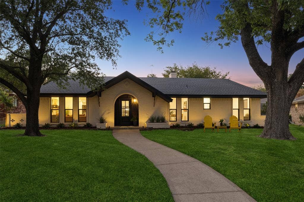 2133 Oak Valley Lane, Dallas, TX 75232 exterior with a dark shingle roof, arched entry, black-framed windows, and a concrete pathway