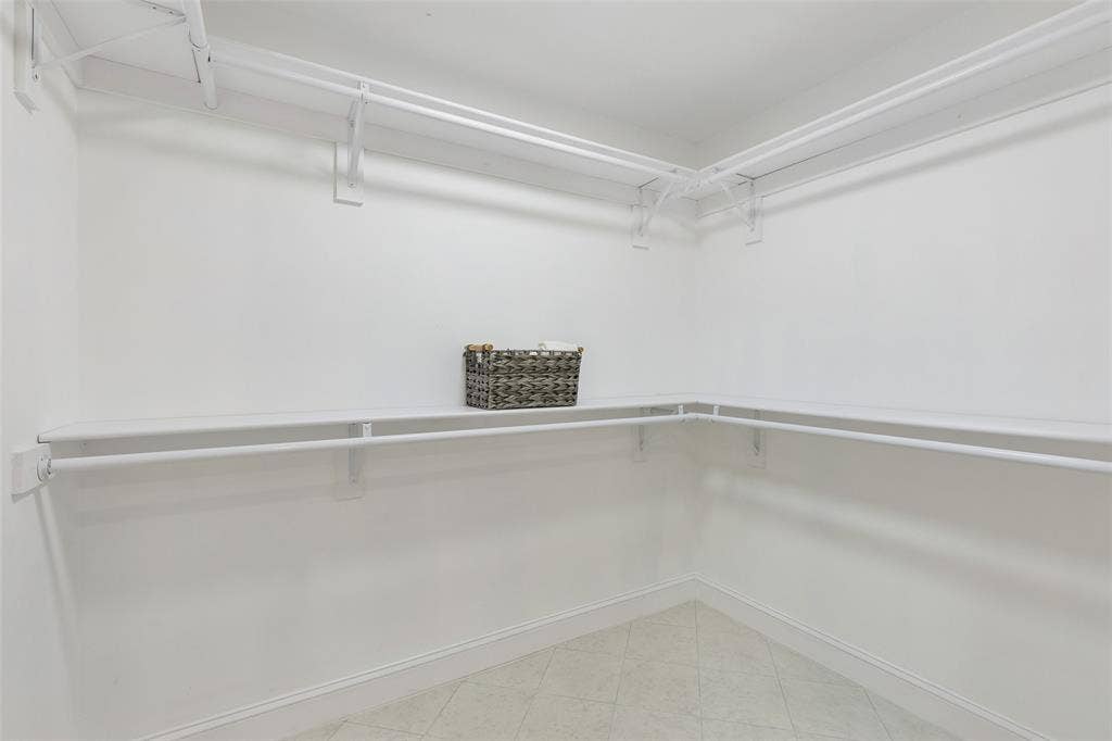 2133 Oak Valley Lane, Dallas, TX 75232 Built-in shelving with hanging rods and a tile floor