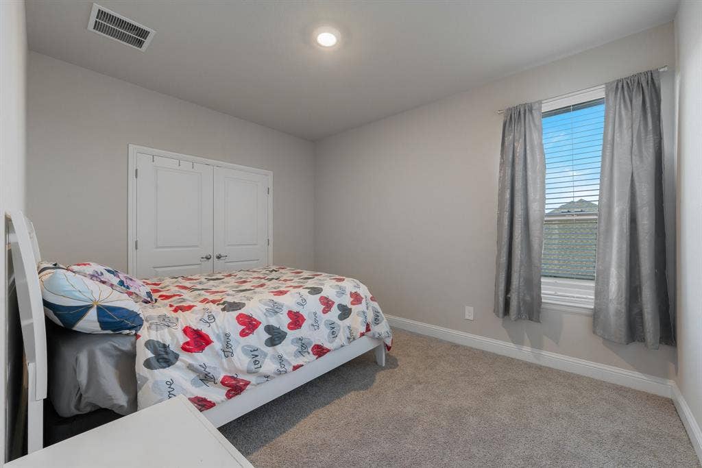 Bedroom #3 with light carpet and a closet