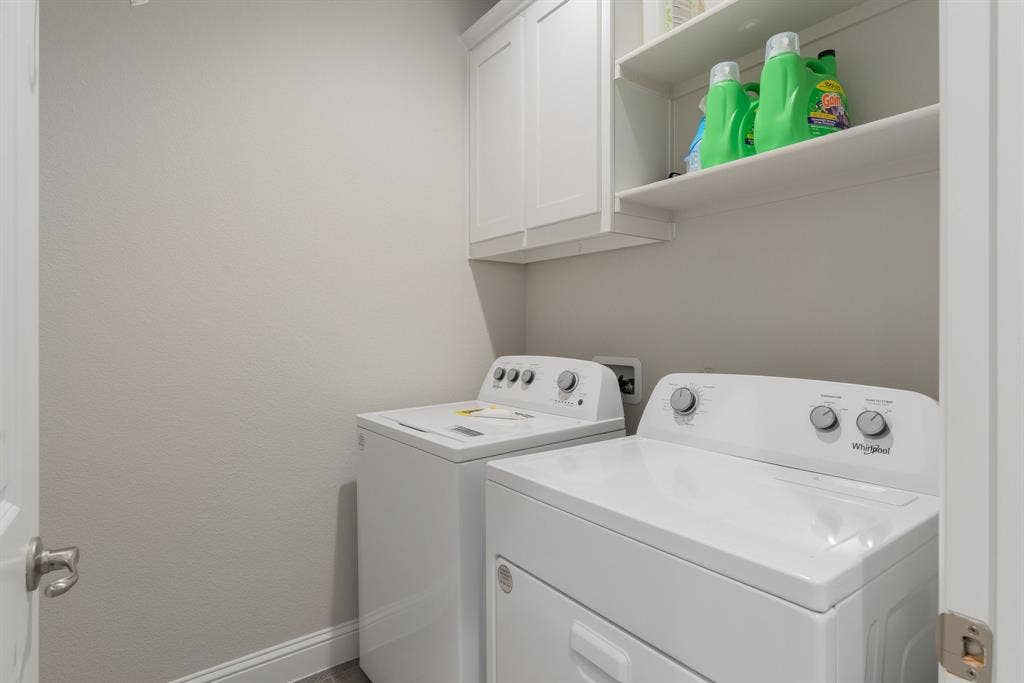 Washroom with cabinet space and washing machine and dryer
