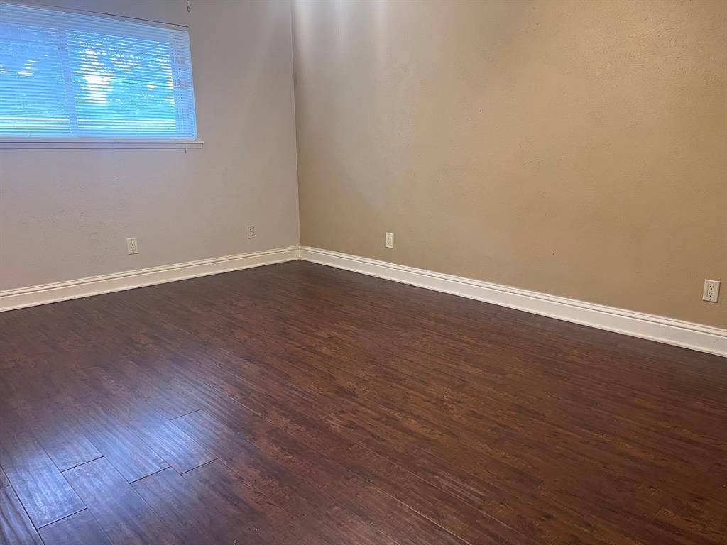 3925 Villa Downs Drive, Plano, TX 75023 Wood-finish flooring with white trim and a window with blinds