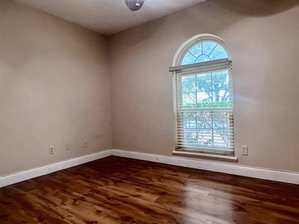3925 Villa Downs Drive, Plano, TX 75023 Arch-top window with blinds and wood-finish flooring